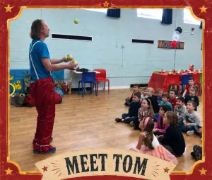 Tom Makin juggling at a children's circus birthday party in Bristol as a group of captivated kids watch from the floor
